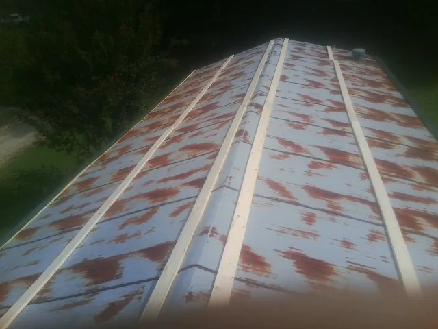 Rusted metal roof panels with new wood purlins before replacement — Storm Damage Roof Repair in Howey In The Hills by Roofing Brothers